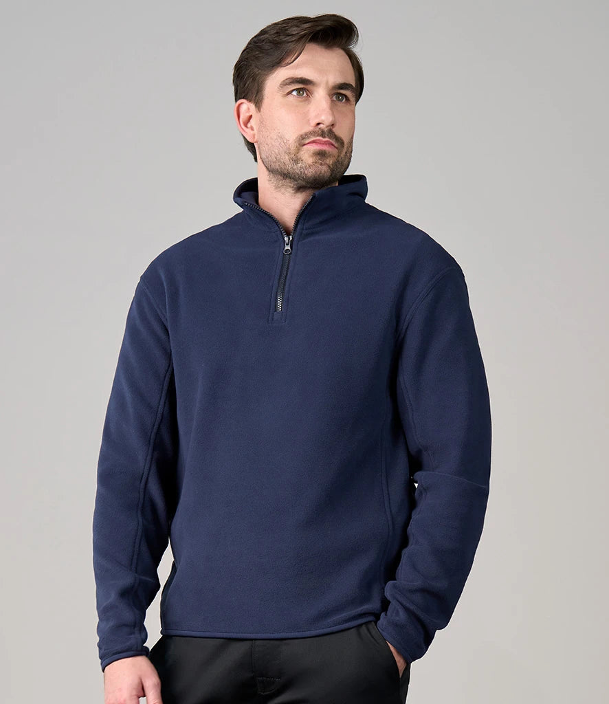 Man wearing a navy blue pullover with a zipper on a gray background