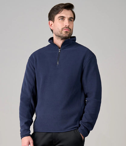 Man wearing a navy blue pullover with a zipper on a gray background